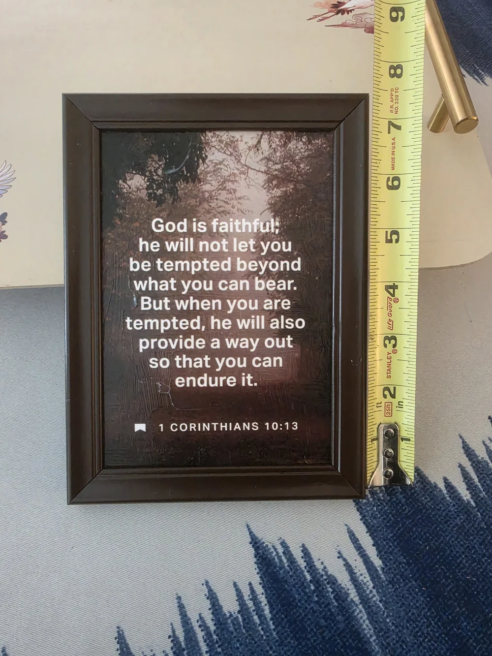 Framed print in the image features the biblical passage 1 Corinthians 10:13